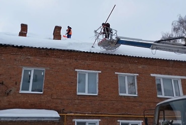 Лотошинские коммунальщики продолжают чистить крыши домов в посёлке Новолотошино от снега