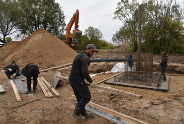 В деревне Калицино рабочие готовят основание площадки под строительство пятиметровой стелы «Населённый пункт воинской доблести»