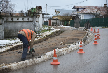 Рабочие монтируют металлическое ограждение на тротуаре возле Лотошинской больницы